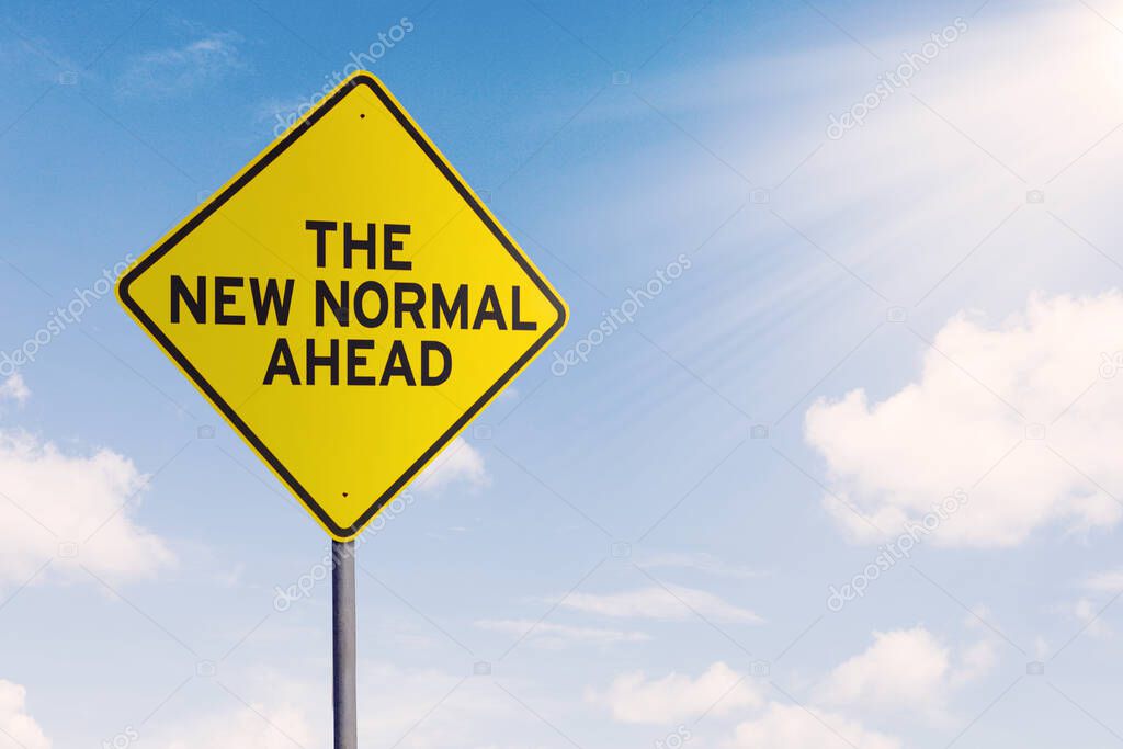 Yellow street sign with text of The New Normal Ahead under clear sky