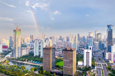 Gökkuşağının güzel gökkuşağı manzarası sakin bir yol ve sabahleyin Jakarta şehrinde gökdelenler.