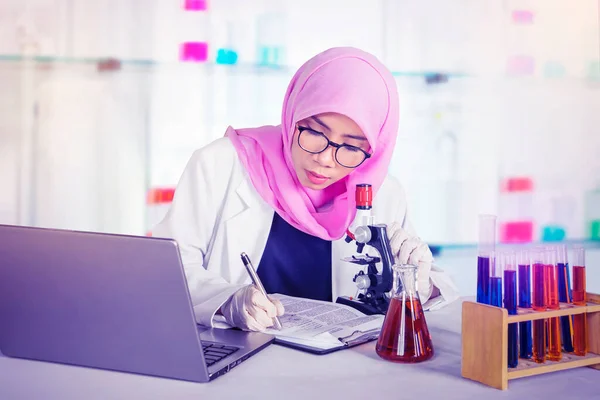 Μουσουλμάνα Επιστήμονας Που Εργάζεται Μικροσκόπιο Και Πρόχειρο Ενώ Πειραματίζεται Στο — Φωτογραφία Αρχείου