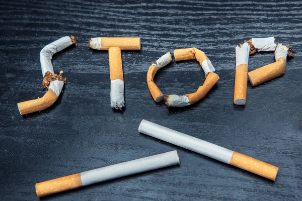 Top view of broken cigarette with Stop smoking sign on the table. Quitting smoking concept