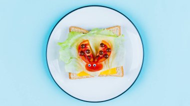 Sebze ve peynirden yapılmış uğurböceği şekilli çocuklar için komik bir kahvaltı tostu.