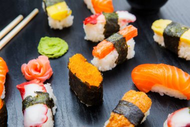 Sashimi suşi setinin kapağı ahşap masanın üzerinde yemek çubukları ve wasabi ile servis edilir.