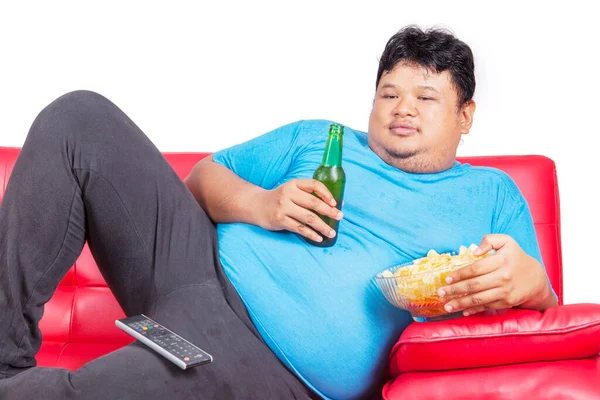 Jovem Gordo Comendo Batatas Fritas Bebendo Uma Cerveja Enquanto Assiste — Fotografia de Stock