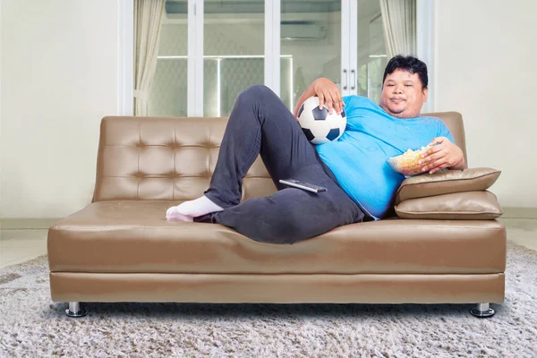 Fat Man Holding Bowl Chips While Lying Sofa Watching Soccer — Stock Photo, Image