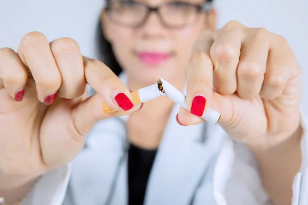 喫煙を停止するために運動しながら 女性医師の手のタバコを破るのを閉じます 喫煙の概念を止める — ストック写真