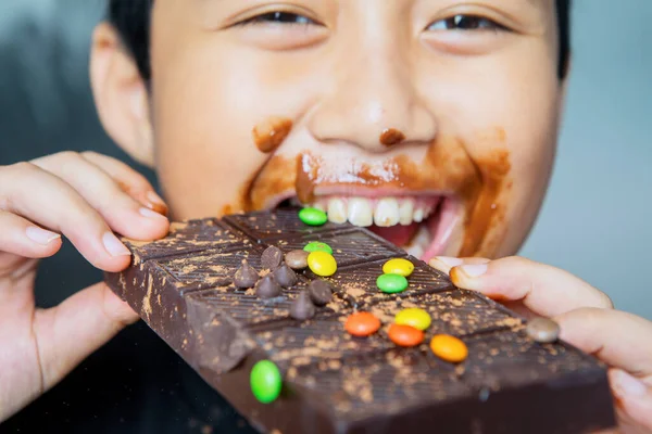 Felice Ragazzino Mordere Mangiare Una Barretta Cioccolato Mentre Guarda Fotocamera — Foto Stock