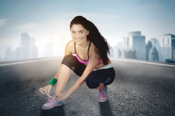 Mujer India Joven Sonriendo Cámara Atándose Los Cordones Los Zapatos — Foto de Stock