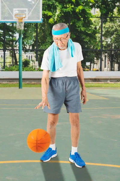 バスケットボールコートでバスケットボールをしながらスポーツウェアを着た先輩 — ストック写真
