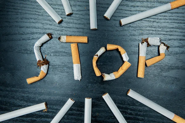 Крупный План Сигарет Расставленных Сломанными Сигаретами Формирующих Стоп Слово Столе — стоковое фото