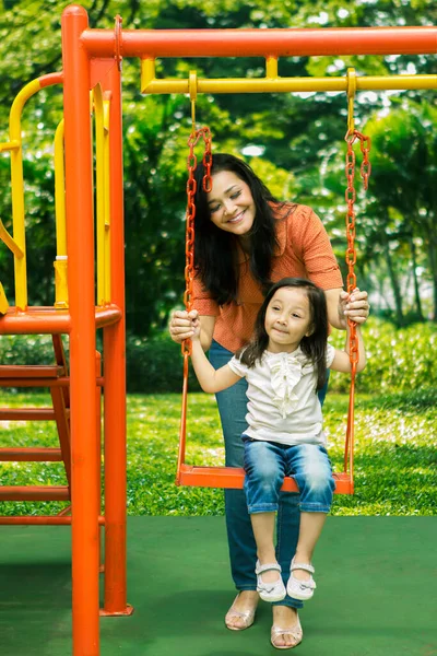 Mulher Bonita Empurrando Seu Filho Balanço Enquanto Brincam Juntos Playground — Fotografia de Stock