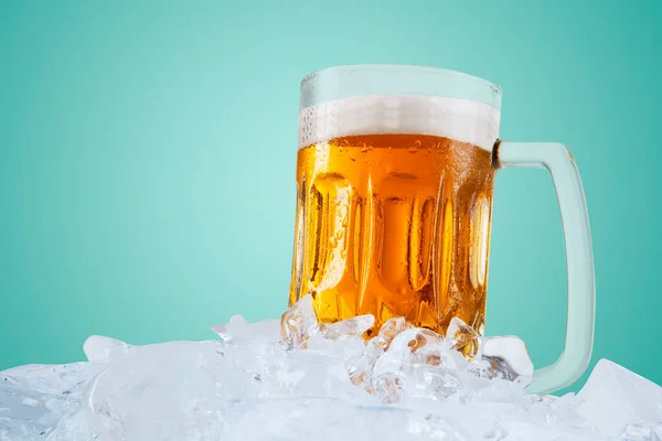 在绿屏背景的冰块堆上的杯子里 把冰啤酒包在一起 — 图库照片