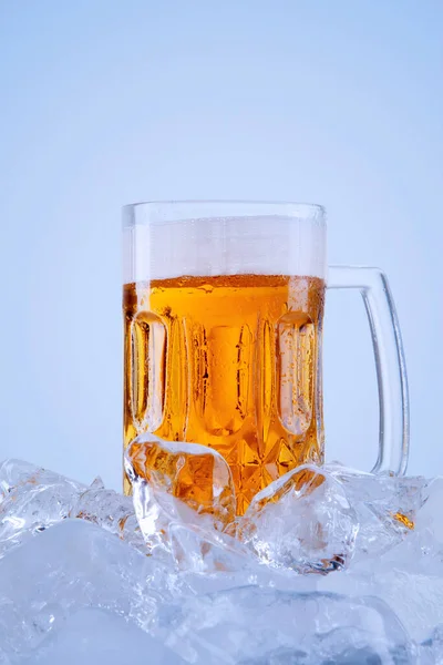 在冰块的堆栈上 用冰镇啤酒制成的玻璃杯盛满泡沫 因白人背景而被隔离 — 图库照片