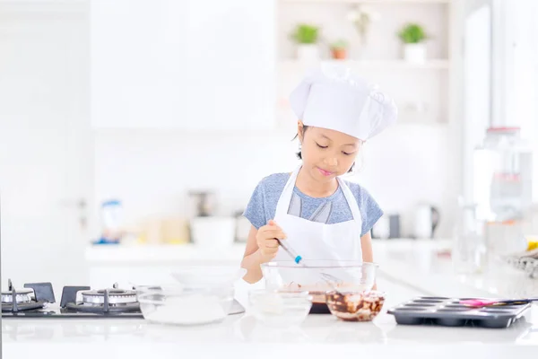 小女孩在厨房里准备自制饼干的时候 在碗里搅拌饼干面团 在家里中弹 — 图库照片