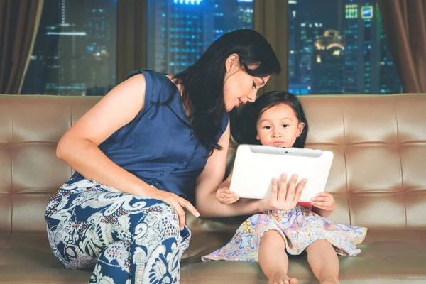 Genç Anne Kızı Kanepede Yan Yana Otururken Dijital Tablet Kullanıyorlar — Stok fotoğraf