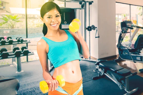 Mulher Asiática Sorrindo Para Câmera Durante Exercício Com Dois Halteres — Fotografia de Stock