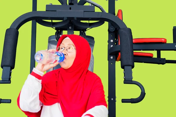 Mulher Muçulmana Sênior Atraente Beber Água Enquanto Sentado Máquina Fitness — Fotografia de Stock
