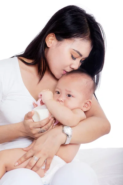 Schöne Mutter Küsst Und Füttert Ihr Baby Während Sie Studio — Stockfoto