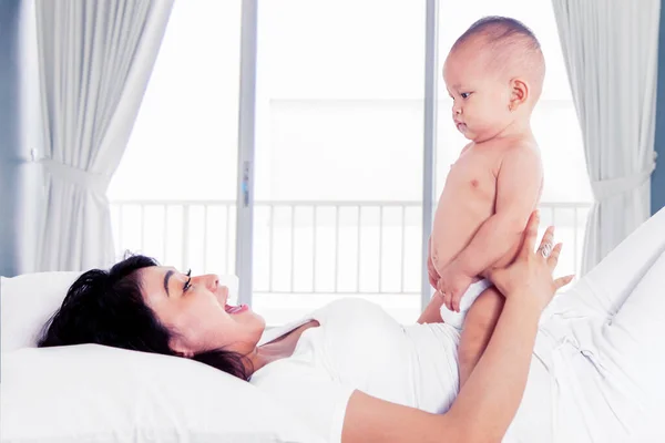 Bela Mãe Deitada Cama Enquanto Brincava Com Seu Bebê Quarto — Fotografia de Stock