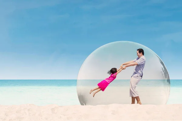 Feliz Padre Girando Hija Playa Mientras Juegan Juntos Burbuja Protectora — Foto de Stock