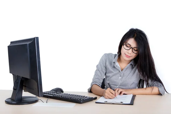 年轻女工坐在电脑前 在剪贴板上写字 坐在工作室里 被白色背景隔离的画像 — 图库照片