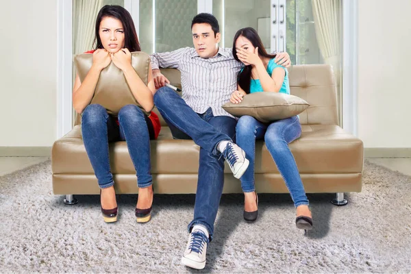 Bir grup korkmuş genç insan birlikte kanepede otururken TV 'de korku filmi izliyorlar. Evde vuruldu.