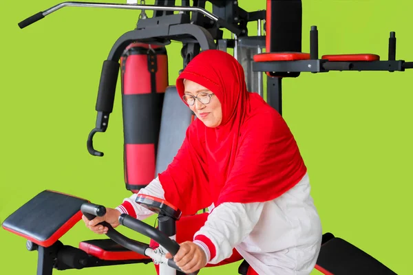 Здоровая Мусульманка Занимающаяся Спортом Велотренажере Фитнес Центре Изолированная Зеленом Фоне — стоковое фото