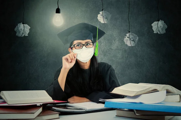 Estudiante Universitaria Con Vestido Graduación Máscara Facial Mientras Piensa Algo — Foto de Stock