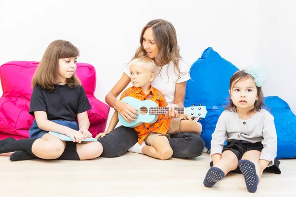 Professor Feliz Ajudando Menino Tocar Guitarra Sentar Com Colega Jardim — Fotografia de Stock