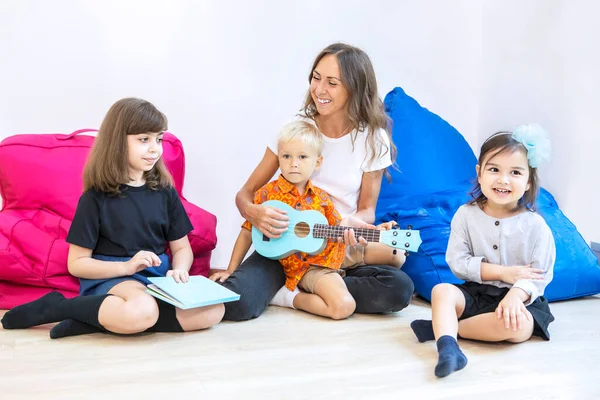 Glückliche Lehrerin Spielt Gitarre Beim Singen Mit Ihren Schülern Kindergarten — Stockfoto