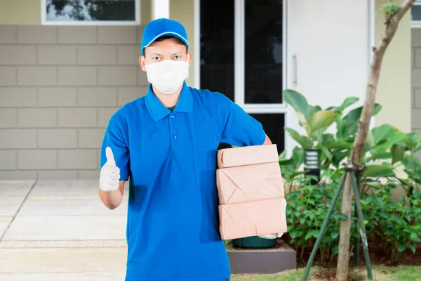 Mężczyzna Kurier Noszenie Maski Twarzy Rękawice Podczas Trzymania Pakiety Pokazując — Zdjęcie stockowe