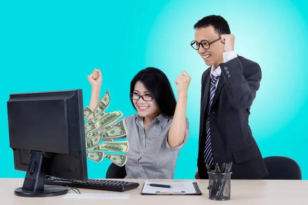 スタジオでコンピューターからお金を探しながら成功を祝う2人のビジネスマン — ストック写真