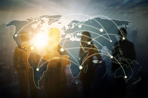 Double exposure of world map with network connection and silhouette of business people standing together with blurred cityscape background