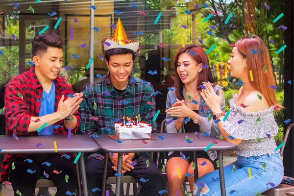 カフェに座っている間 彼らの友人のための誕生日パーティーを祝いながら 手をたたいて一緒に歌う人々を微笑む — ストック写真
