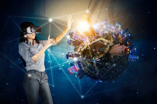 Young businesswoman wearing virtual reality headset while working with network connection and smart city on virtual screen