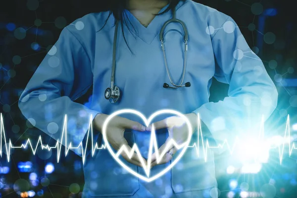 女性外科医生双手在心脏脉动信号背景下制作心脏符号的双重曝光 — 图库照片
