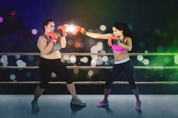背景がぼやけているリングで戦う2人の女性ボクサーの写真 — ストック写真