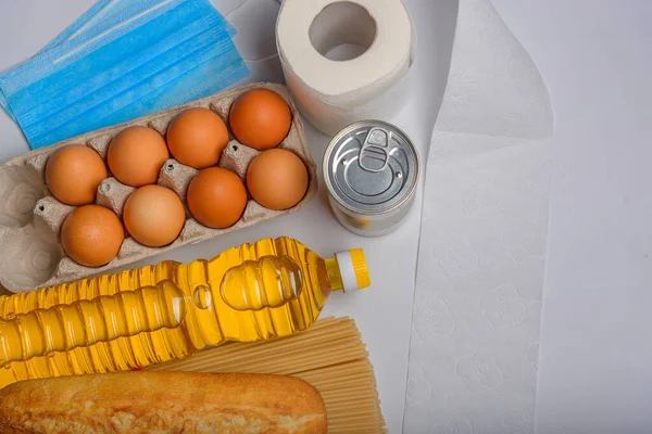 A set of different products for donation. Canned food, eggs, fruits and vegetables on a white background, flat lay, copy-space