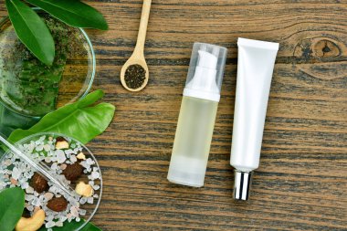 Kozmetik şişe kapları ile yeşil bitki yaprakları, marka mock-up, doğal organik güzellik ürün kavramı için boş etiket paketi.