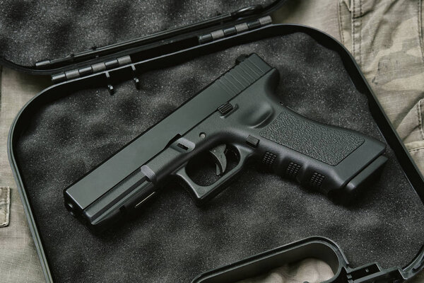 Пистолет 9 мм, оружейная серия, полицейский пистолет крупным планом на камуфляжном фоне
.