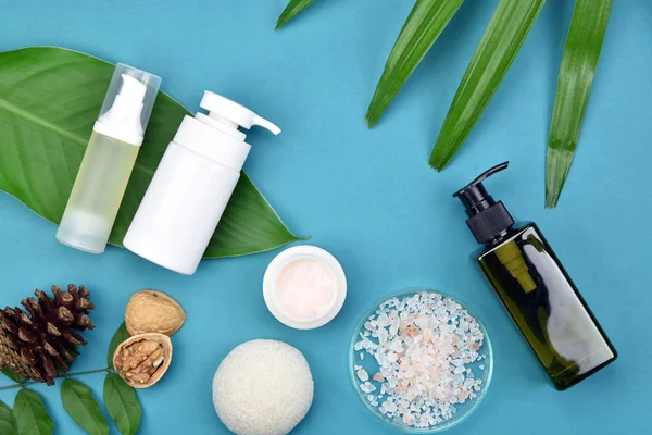 Kozmetik Cilt bakım şişe kapları ile yeşil bitki yaprakları, marka mock-up, doğal organik güzellik ürün kavramı için boş etiket paketi.