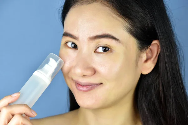 Recipientes de botellas cosméticas con etiqueta en blanco para maquetas de marca, mujeres de rostro desnudo asiáticas que muestran productos para el cuidado de la piel . — Foto de Stock