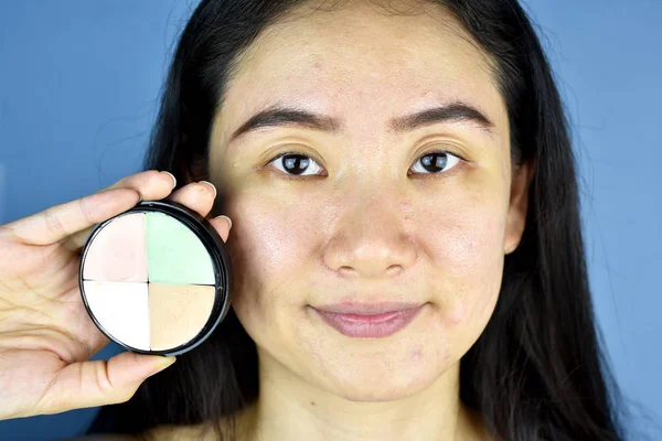 Cosméticos y corrector, mujer asiática mostrando paleta correctora de color . — Foto de Stock