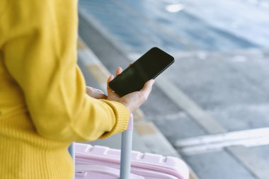 Havaalanında taksi servisi rezervasyonu için akıllı telefon uygulamasını kullanan yolcu, Seyahat ve toplu taşıma konsepti.