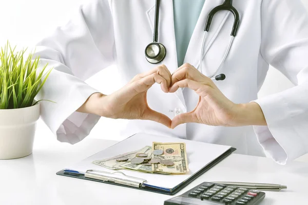 Health and medical insurance, Doctor doing a hand heart shape over dollar banknotes, Money saving for medical and healthcare services.