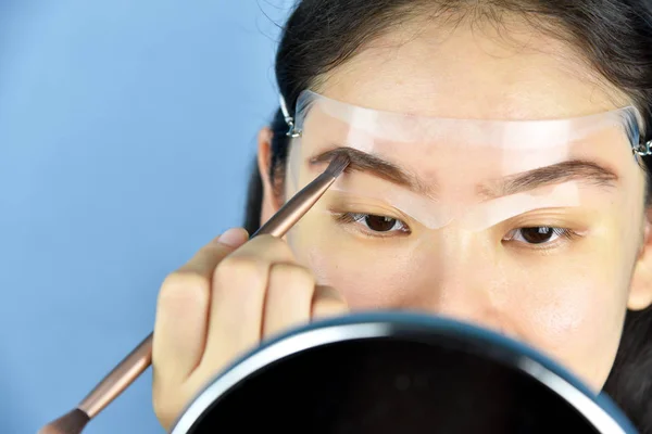 Las cejas que forman la plantilla del maquillaje, mujeres asiáticas que llenan las cejas para mirar más gruesas, aprendiendo haciendo el maquillaje del uno mismo . — Foto de Stock