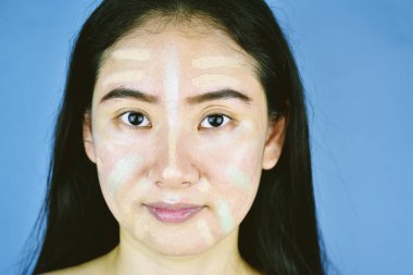 Asyalı kadın kozmetik makyaj uygulayarak ve renk düzeltme kapatıcı kullanarak, Yüz daha iyi cilt tonu için hazırlanıyor, Öğrenme kendini makyaj yapıyor.