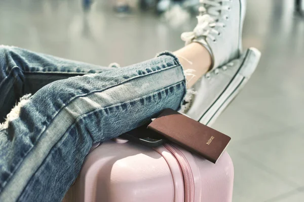 Reiziger wachten op vlucht check-in op de luchthaven, passagier rusten haar voeten op koffer in afwachting Transfer Terminal, vertraagde vlucht. — Stockfoto