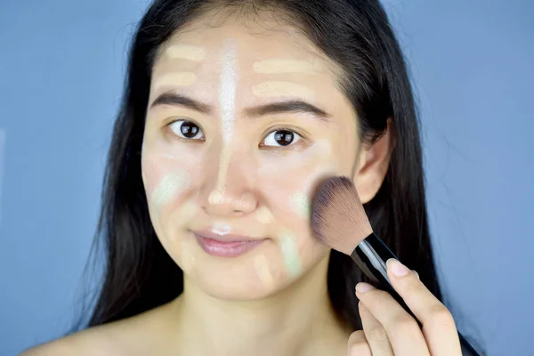 Mujer asiática que aplica maquillaje cosmético y usa corrector de color corrector corrector, la piel de la cara se prepara antes de la fundación del maquillaje, aprender a maquillarse . — Foto de Stock