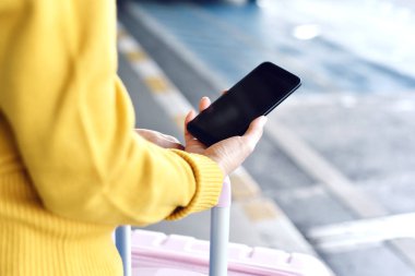 Havaalanında online rezervasyon taksi aracı hizmeti için akıllı telefon uygulamasını kullanan yolcu, Seyahat ve toplu taşıma konsepti. 