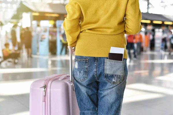 Reiziger staat met een bagage op de luchthaven terminal, passagier lopen naar check-in balie, toerist aankomen op bestemming, reis concept. — Stockfoto